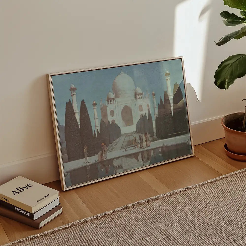 Painting of the Taj Mahal framed and leaning against a wall, with a plant and books nearby.