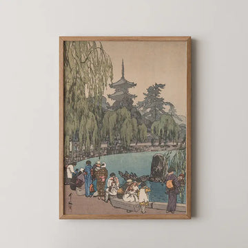 Hiroshi Yoshida woodblock print of visitors gathered at a stone pagoda pond watching carp and tortoises beneath willow trees.